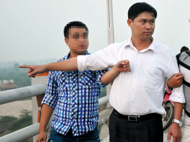Bác sĩ Nguyễn Mạnh Tường (áo trắng) thuật lại vụ việc với cơ quan điều tra tại cầu Thanh Trì (bắc qua sông Hồng).
