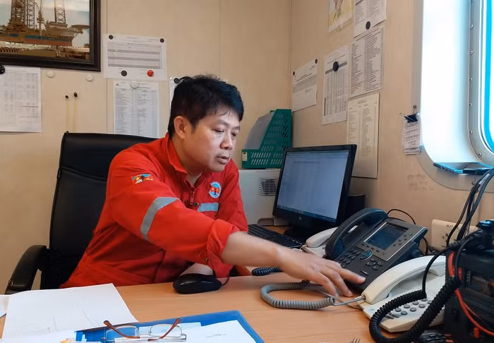 Anh Nguyễn Hải - Giàn trưởng Giàn khoan tự nâng Tam Đảo 02 đang thực hiện nhiệm vụ báo cáo công việc. Mỗi ngày, giàn trưởng phải thực hiện ít nhất 2 lần báo cáo về đất liền và phải chịu trách nhiệm chung cho toàn bộ mọi hoạt động trên giàn.