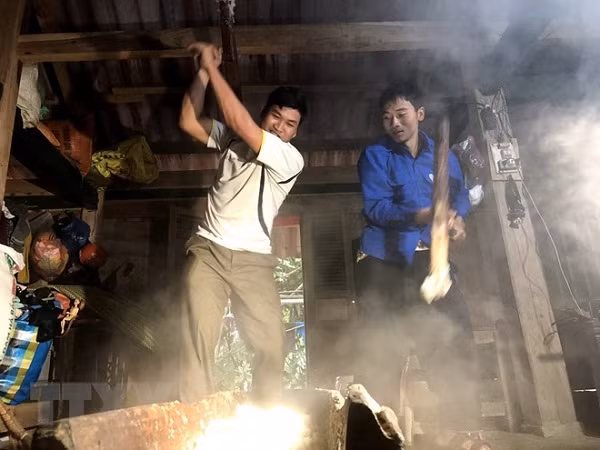 Các thanh niên tham gia giã bánh dày trong ngày tết người Mông. (Ảnh: Hữu Quyết/TTXVN)