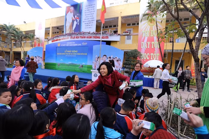 Bà Bùi Thị Hương – Giám đốc Điều hành Vinamilk trao sữa cho các em học sinh.