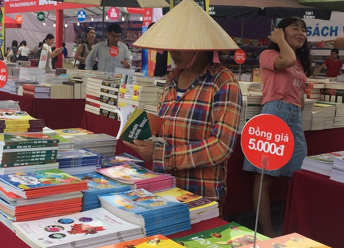 Hình ảnh một chị công nhân sau khi hoàn thành xong công việc của mình đã ghé vào Hội sách Hà Nội lần thứ IV để tìm mua những cuốn sách yêu thích (Ảnh: Ngọc Bích).