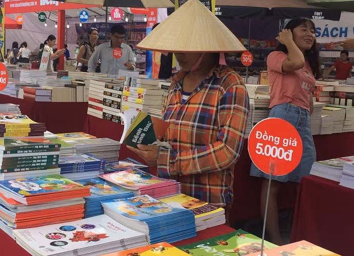 Hình ảnh một chị công nhân sau khi hoàn thành xong công việc của mình đã ghé vào Hội sách Hà Nội lần thứ IV để tìm mua những cuốn sách yêu thích (Ảnh: Ngọc Bích).