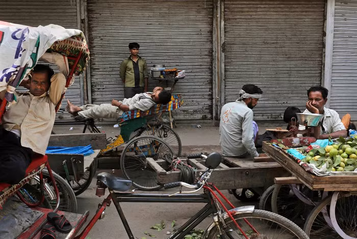 Những người bán hàng rong và xe kéo tại một khu chợ đã đóng cửa trong một cuộc đình công toàn quốc tại New Delhi, Ấn Độ. Cuộc biểu tình rộng khắp nhằm phản đối giá dầu tăng cao và việc chính phủ quyết định mở cửa cho các hệ thống siêu thị nước ngoài đầu tư vào Ấn Độ.