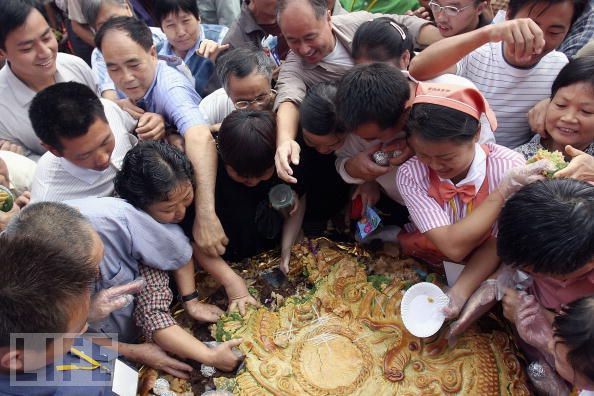 Người dân đổ xô kiếm cho mình một phần của chiếc bánh trung thu khổng lồ. Người dân đổ xô kiếm cho mình một phần của chiếc bánh trung thu khổng lồ.