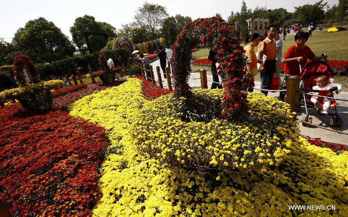 Du khách ngắm hoa tại một chương trình trưng bày hoa trong Vườn Bách thảo Thượng Hải ở thành phố Thượng Hải.