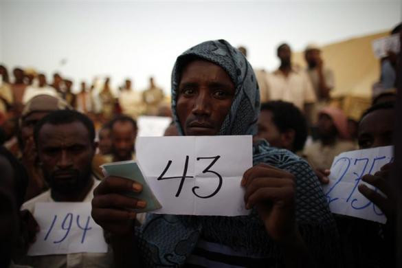 Hay vất vả đứng chờ bên ngoài trung tâm quá cảnh của Tổ chức Di cư Quốc tế (IOM). Hay vất vả đứng chờ bên ngoài trung tâm quá cảnh của Tổ chức Di cư Quốc tế (IOM).