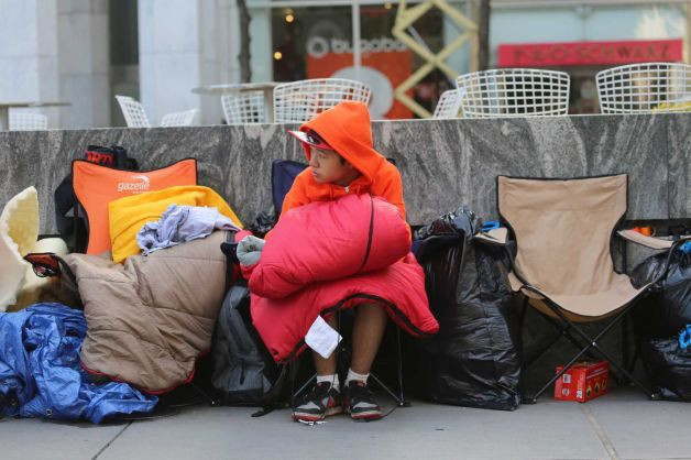 Một thanh niên chờ bên ngoài cửa hàng Apple ở New York. Một thanh niên chờ bên ngoài cửa hàng Apple ở New York.