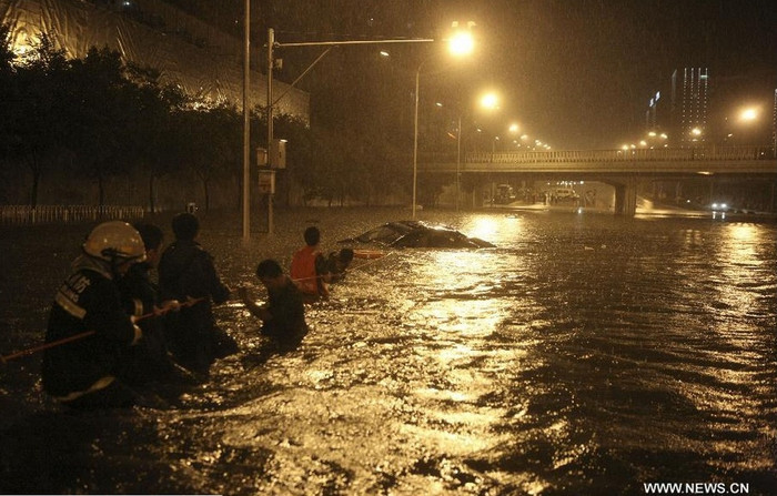 Lực lượng cứu hộ giải cứu một chiếc xe hơi đã gần như bị ngập hoàn toàn.