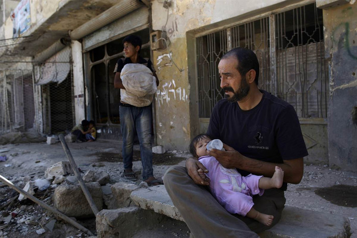 Một người đàn ông Syria cho con gái của mình uống sữa khi đang ngồi ở phía trước ngôi nhà của mình đã bị tàn phá ở Azaz, vùng ngoại ô Aleppo, Syria. Một người đàn ông Syria cho con gái của mình uống sữa khi đang ngồi ở phía trước ngôi nhà của mình đã bị tàn phá ở Azaz, vùng ngoại ô Aleppo, Syria.