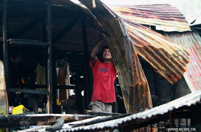 Một người dân đang cố gắng sửa chữa căn nhà lụp xụp của mình.