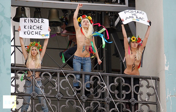 Thành viên FEMEN đứng ngoài ban công nhà thờ và hô to. Thành viên FEMEN đứng ngoài ban công nhà thờ và hô to.