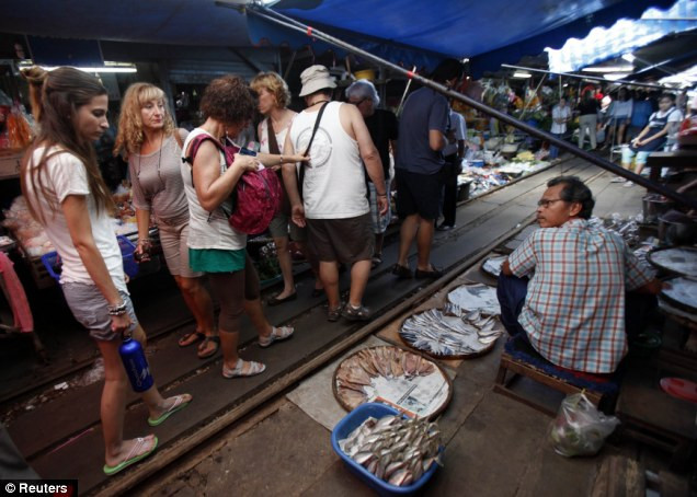 Kẻ mua người bán vẫn điềm tĩnh đi lại trên đường ray. Kẻ mua người bán vẫn điềm tĩnh đi lại trên đường ray.