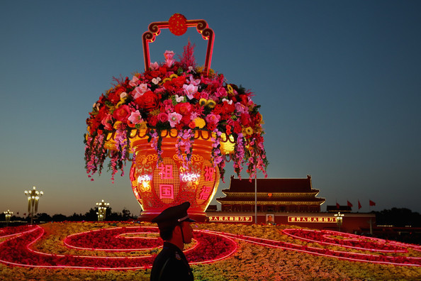 Một người lính đứng gác bên cạnh bình hoa khổng lồ.