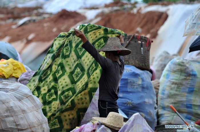 Một người phụ nữ tìm được tấm ga giường còn khá nguyên vẹn. Một người phụ nữ tìm được tấm ga giường còn khá nguyên vẹn.