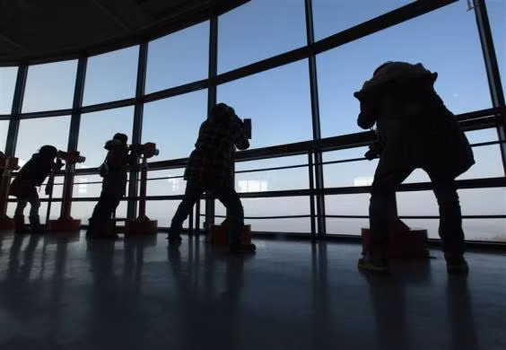 Các khách du lịch nhìn về phía Triều Tiên qua ống nhòm tại Đài quan sát gần khu DMZ ngăn cách hai miền