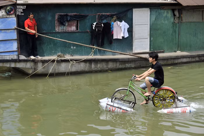 Một thanh niên Vũ Hán chế ra chiếc "xe đạp lội nước" đi trên sông Hán Giang, một nhánh của sông Dương Tử tại Vũ Hán, tỉnh Hồ Bắc.