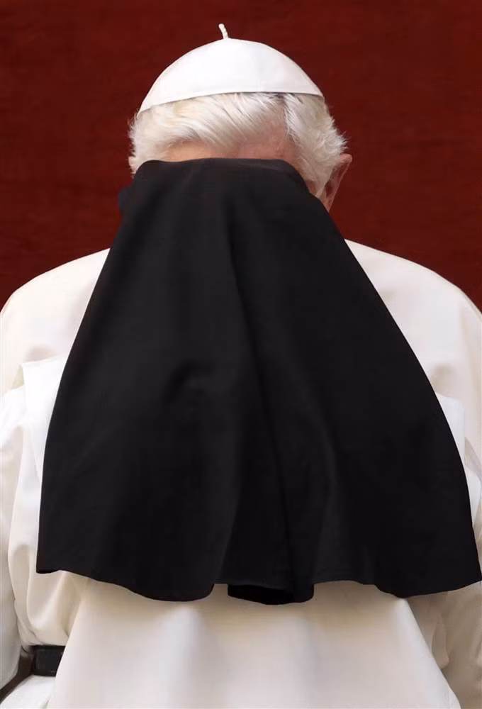 Giáo hoàng Benedict XVI bị che khuất bởi một nữ tu đang chào mừng ông trong buổi giảng đạo hàng tuần tại Castel Gandolfo, vùng ngoại ô Rome.