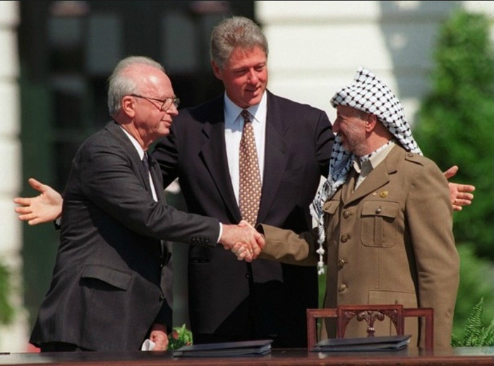Thủ tướng Israel - Yitzhak Rabin (trái) và Yasser Arafat, nhà lãnh đạo của Tổ chức Giải phóng Palestine, bắt tay trước một đám đông trên bãi cỏ Nhà Trắng vào ngày 13/9/1993. Đây là cái bắt tay đầu tiên trước công chúng của hai nhà lãnh đạo trong các cuộc đàm phán hòa bình giữa Israel và các vùng lãnh thổ Palestine. Mặc dù tương đối lạc quan, thỏa thuận đã không bao giờ trở thành hiện thực. Thủ tướng Israel - Yitzhak Rabin (trái) và Yasser Arafat, nhà lãnh đạo của Tổ chức Giải phóng Palestine, bắt tay trước một đám đông trên bãi cỏ Nhà Trắng vào ngày 13/9/1993. Đây là cái bắt tay đầu tiên trước công chúng của hai nhà lãnh đạo trong các cuộc đàm phán hòa bình giữa Israel và các vùng lãnh thổ Palestine. Mặc dù tương đối lạc quan, thỏa thuận đã không bao giờ trở thành hiện thực.