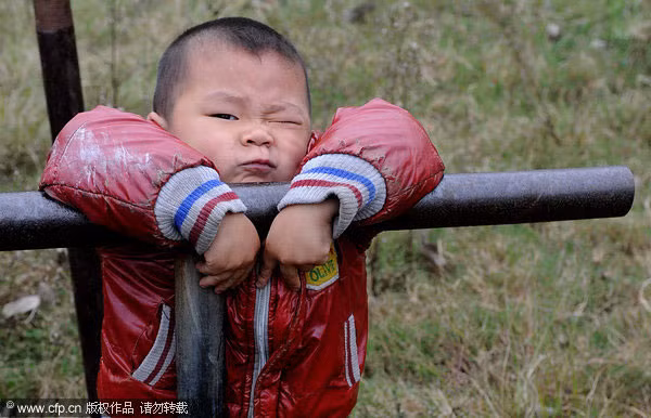 Cậu bé Yang Nieyuanzhang, 5 tuổi, chơi trên xà kép.