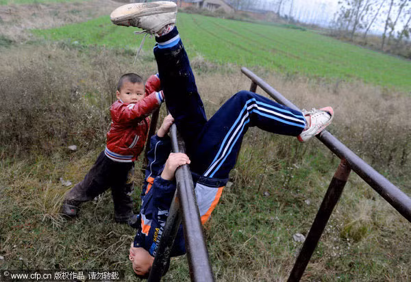 Yang Nieyuan và Li Juncheng chơi trên xà kép – thiết bị thể dục duy nhất tại trường học ở làng Shuangmiao