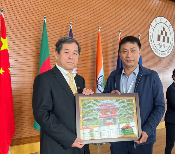 Thầy Nguyên tặng quà lưu niệm cho Ban tổ chức Tuần lễ giao lưu thể thao và văn hóa các trường đại học khu vực Đông Nam Á và Nam Á diễn ra tại Côn Minh – Trung Quốc. (Ảnh: NTCC) Thầy Nguyên 3.PNG