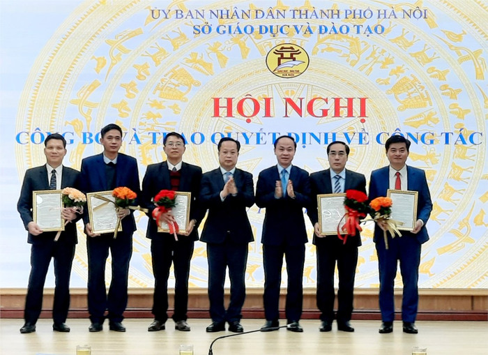 Lãnh đạo Sở Giáo dục và Đào tạo Hà Nội trao quyết định và tặng hoa cho các cán bộ quản lý các trường công lập. (Ảnh: Sở Giáo dục và Đào tạo Hà Nội). t0_2032024168.jpg