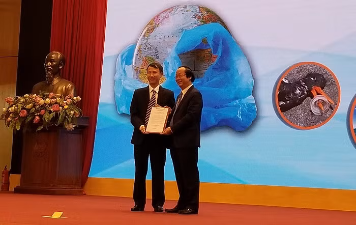 Ông Phạm Duy Hưng – Giám đốc Pháp lý và Đối ngoại FrieslandCampina Việt Nam (trái) trao cam kết chống rác thải nhựa cho ông Võ Tuấn Nhân – Thứ trưởng Bộ Tài nguyên và Môi trường.