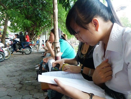 Thí sinh tranh thủ xem lại bài trước giờ vào phòng thi tại HV Ngoại giao (Ảnh Kim Ngân)