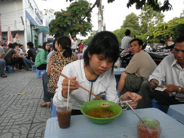 Tới giờ vào phòng thi nhưng thí sinh Đỗ Thị Thanh Lộc vẫn còn nhàn nhã bên tô bún bò Huế. Ảnh chụp trước điểm thi trường CĐ Bách Việt (đường Nguyễn Thái Sơn, Gò Vấp). Ảnh: Dương Cầm