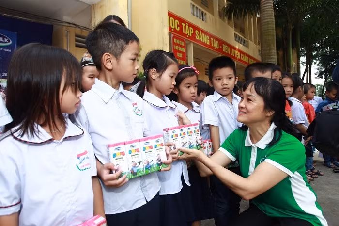 Bà Nguyễn Minh Tâm – Giám đốc Chi nhánh Vinamilk tại Hà Nội trao quà cho các em học sinh.