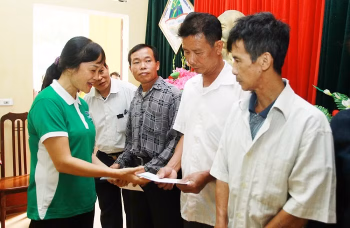 Bà Nguyễn Minh Tâm – Giám đốc Chi nhánh Vinamilk tại Hà Nội trao quà cho các hộ dân gặp khó khăn.