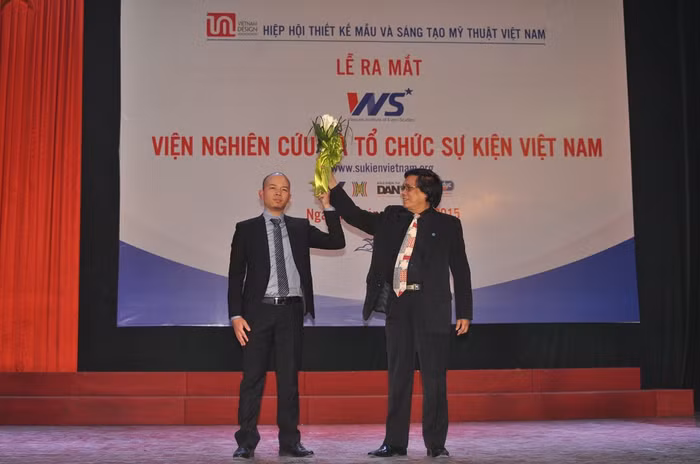 PGS.TS. Họa sỹ Lê Huyên - Chủ tịch Hiệp hội Thiết kế mẫu và Sáng tạo Mỹ thuật Việt Nam (phải) tặng hoa chúc mừng tân Viện trưởng Viện Nghiên cứu và Tổ chức Sự kiện Việt Nam- Thạc sỹ Trần Xuân Dũng.