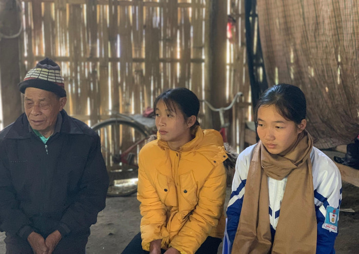 Mùng Thị Lệ (bên phải) và em gái Mùng Thị Thùy Linh bên ông nội trong ngôi nhà cũ nát của gia đình. Ảnh: C.K.A. Mùng Thị Lệ (bên phải) và em gái Mùng Thị Thùy Linh bên ông nội trong ngôi nhà cũ nát của gia đình. Ảnh: C.K.A.