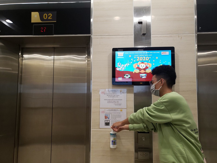 Người dân sử dụng nước rửa tay sát khuẩn tại khu vực công cộng trong chung cư Imperia Sky Garden.