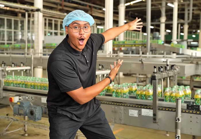 Các sinh viên đã có những giây phút hào hứng bên những chai Trà xanh Không độ vừa qua công đoạn tròng nhãn chai.