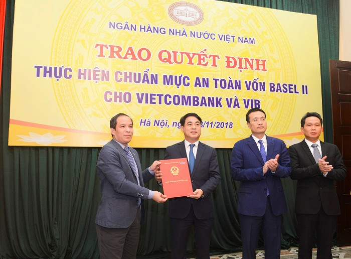 Đại diện Ban Lãnh đạo Ngân hàng nhà nước Việt Nam, ông Đoàn Thái Sơn – Phó Thống đốc (ngoài cùng bên trái) trao quyết định công nhận Vietcombank thực hiện chuẩn mực an toàn vốn Basel II (đại diện Ban Lãnh đạo Vietcombank nhận quyết định: Ông Nghiêm Xuân Thành – Chủ tịch Hội đồng quản trị (thứ 2 từ trái sang; ông Phạm Quang Dũng – Tổng Giám đốc, Trưởng Ban triển khai chương trình Basel II (thứ 2 từ phải sang) và ông Nguyễn Mạnh Hùng - Ủy viên Hội đồng quản trị, Phó Trưởng Ban thường trực Ban triển khai chương trình Basel II Vietcombank (ngoài cùng bên phải).