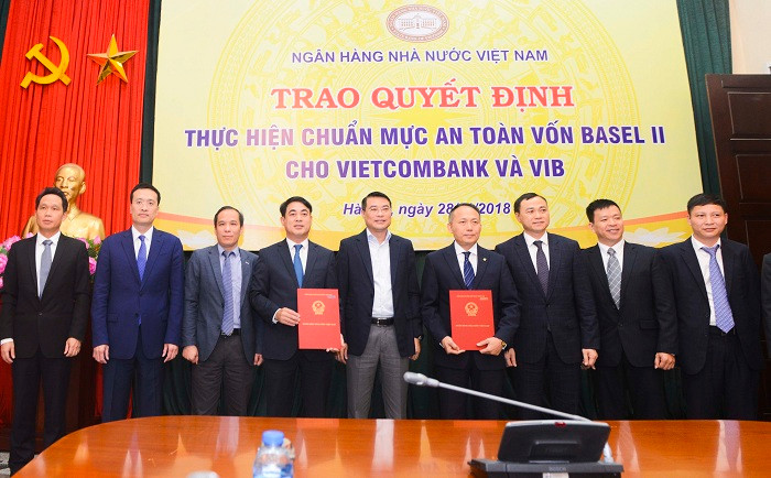 Thống đốc Ngân hàng nhà nước Việt Nam Lê Minh Hưng (đứng giữa) cùng Phó Thống đốc Ngân hàng nhà nước Đoàn Thái Sơn (thứ 3 từ trái sang) chúc mừng và chụp ảnh lưu niệm cùng Ban Lãnh đạo Vietcombank và các đại biểu.
