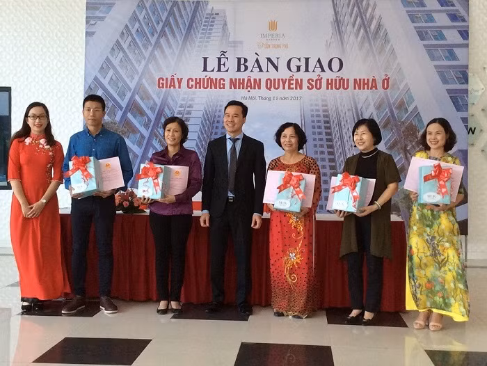 Đại diện chủ đầu tư trao Giấy chứng nhận sở hữu nhà ở cho cư dân.