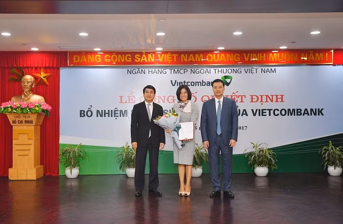 Chủ tịch Hội đồng quản trị Vietcombank Nghiêm Xuân Thành (bên trái) và Tổng Giám đốc Vietcombank Phạm Quang Dũng (bên phải) trao Quyết định và tặng hoa chúc mừng Bà Phùng Nguyễn Hải Yến – tân Phó Tổng Giám đốc Vietcombank.