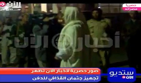 Giáo sĩ riêng của Đại tá Gaddafi đang cầu nguyện cho ông trong tang lễ được tổ chức theo phong cách Hồi giáo truyền thống Giáo sĩ riêng của Đại tá Gaddafi đang cầu nguyện cho ông trong tang lễ được tổ chức theo phong cách Hồi giáo truyền thống