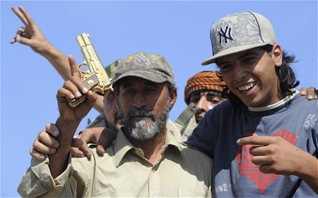 Mohammed el-Bibi (phải) và khẩu súng vàng được cho là Đại tá Gaddafi đã sử dụng trước khi bị bắt Mohammed el-Bibi (phải) và khẩu súng vàng được cho là Đại tá Gaddafi đã sử dụng trước khi bị bắt