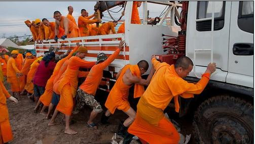 Các nhà sư đẩy một xe tải bị lún xuống bùn vì lũ lụt ở ngoại ô Bangkok - Ảnh: Getty Images Các nhà sư đẩy một xe tải bị lún xuống bùn vì lũ lụt ở ngoại ô Bangkok - Ảnh: Getty Images