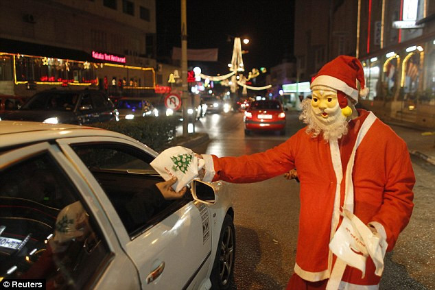Một ông già Noel tặng quà cho trẻ em trên quảng trường Manger trong đêm Noel Một ông già Noel tặng quà cho trẻ em trên quảng trường Manger trong đêm Noel