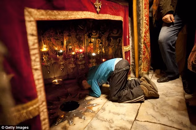 Một cậu bé cầu nguyện tại hang trong nhà thờ Bethlehem Một cậu bé cầu nguyện tại hang trong nhà thờ Bethlehem