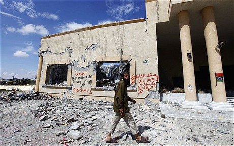 Tay súng ủng hộ lực lượng NTC đang chuẩn bị bước vào Trung tâm Hội nghị Ouagadougou ở Sirte hôm 9/10. Tay súng ủng hộ lực lượng NTC đang chuẩn bị bước vào Trung tâm Hội nghị Ouagadougou ở Sirte hôm 9/10.