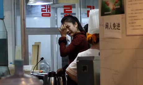 Một nữ bồi bàn khóc phía sau một nhà hàng Triều Tiên tại Bắc Kinh khi nghe tin Chủ tịch Kim đã qua đời