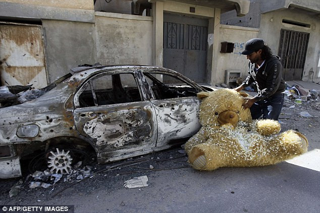 Một con gấu bông lớn bị bỏ lại bên cạnh chiếc xe cháy đen ở Sirte Một con gấu bông lớn bị bỏ lại bên cạnh chiếc xe cháy đen ở Sirte