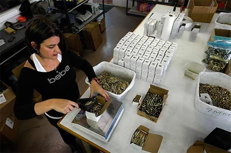 Nhân viên Elsie Garcia cân chiếc hộp gồm các viên đạn 5,56 mm trước khi đóng gói.