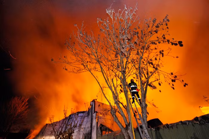 Lính cứu hỏa đang cố gắng dập lửa trong một đám cháy nhà kho chứa giấy cuộn của một xưởng in báo tại Forest-sur-Marque, Pháp hôm 25/11.