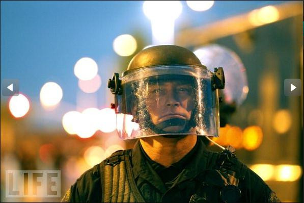 Một cảnh sát chống bạo động đứng gác ở lối vào cảng Oakland để ngăn người biểu tình đang cố gắng thâm nhập vào bên trong.